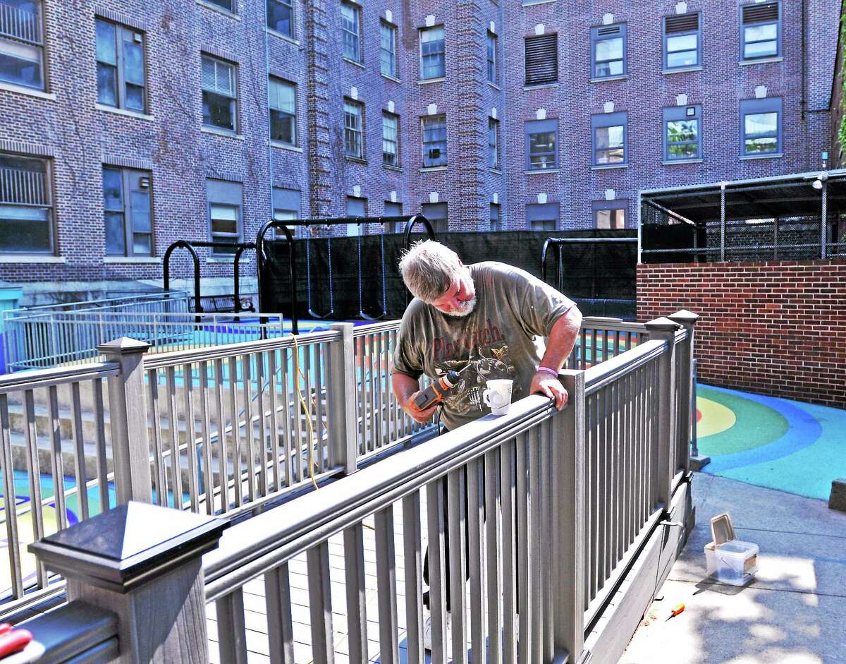Don Lamy of Lamy’s Remodeling in Thomaston puts the finishing touches on a deck in the Terry’s Dream playground area at the Children’s Psychiatric Inpatient Center (Yale). Lamy donated the materials and construction of the deck to the center.