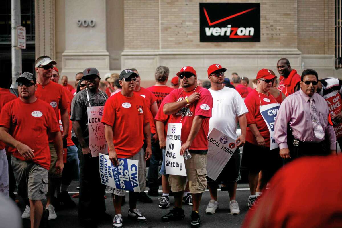 In this Aug. 8, 2011, photo, Verizon workers picket outside one of the company’s central offices, in Philadelphia.