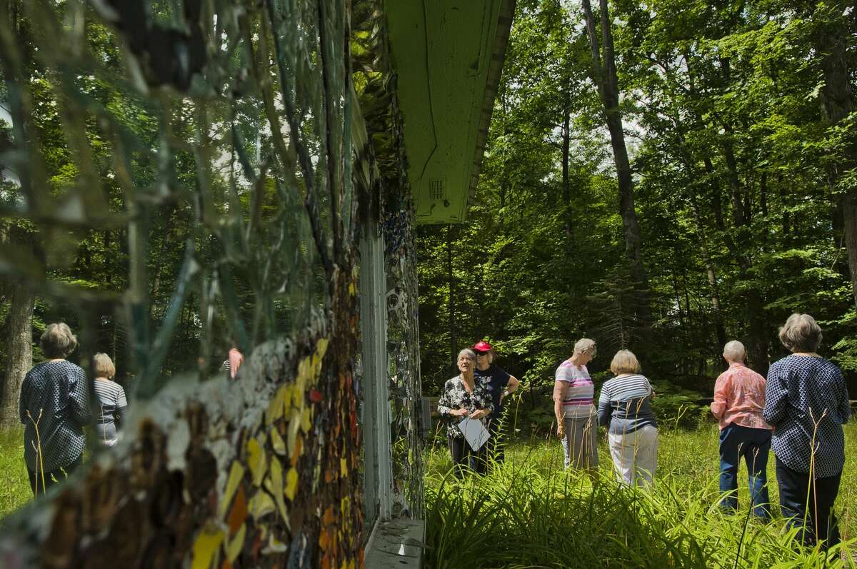 A tour group from Creative 360 checks out the John Pratt Mosaic House at 102 E. Isabella Road on Tuesday, July 25, 2017. Artist John Pratt covered the home, which he grew up in, with mosaic murals made of broken pieces of pottery, china and mirrors.