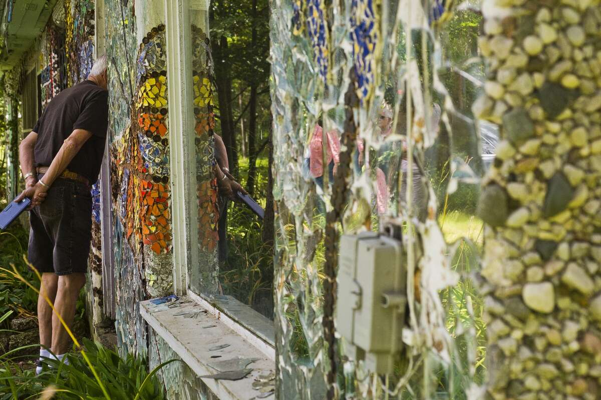 A tour group from Creative 360 checks out the John Pratt Mosaic House at 102 E. Isabella Road on Tuesday, July 25, 2017. Artist John Pratt covered the home, which he grew up in, with mosaic murals made of broken pieces of pottery, china and mirrors.