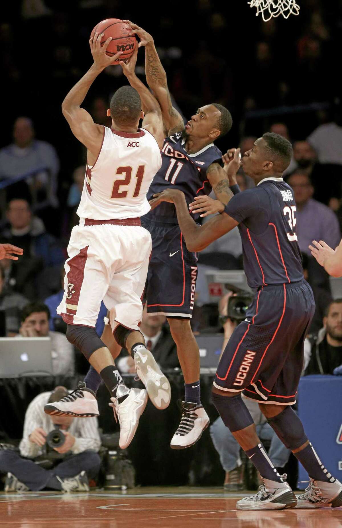 UConn’s Ryan Boatright, center, gets his hand on a shot by Boston College’s Olivier Hanlan, left, while Amida Brimah looks on during the first half Thursday.