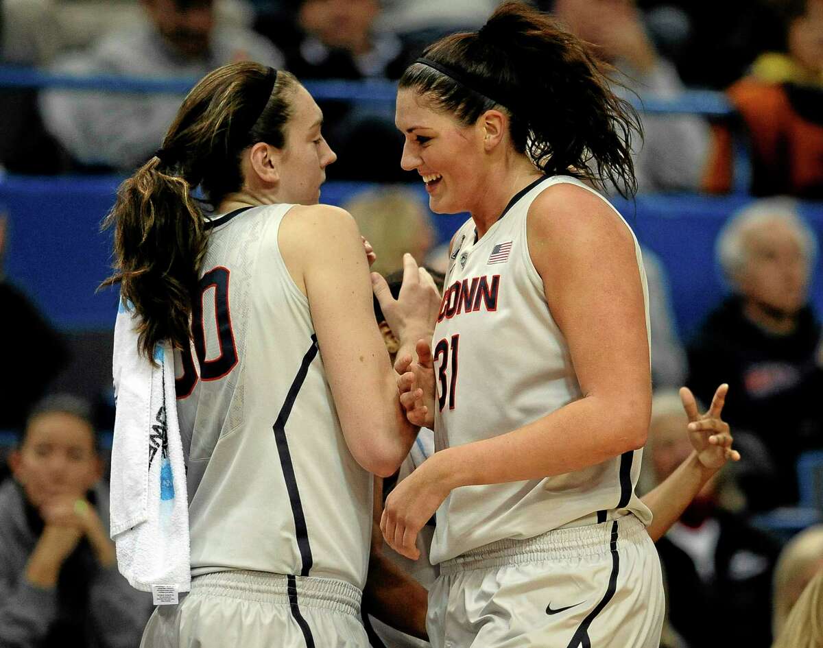 UConn’s Stefanie Dolson, right, is greeted by teammate Breanna Stewart after completing a triple-double in Wednesday’s 114-68 win over Oregon.