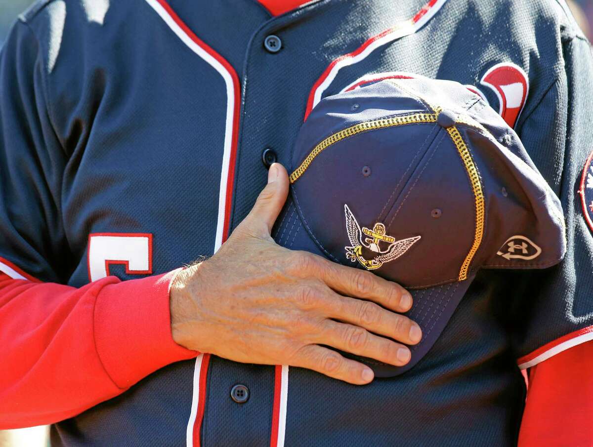 Washington manager Davey Johnson holds a Navy hat over his heart during a moment of silence before the Nationals’ game against the Atlanta Braves at Nationals Park on Tuesday in Washington. The Nationals wore Navy hats, presented to them before the game, by Adm. James A. Winnefield, vice-chairman of the Joint Chiefs of Staff, to honor those killed and injured in the attack Monday at the nearby Washington Navy Yard.