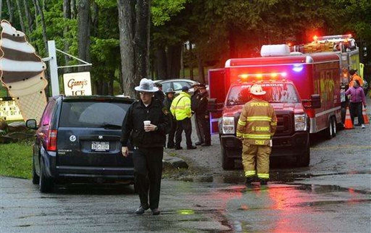 In this Friday, May 24, 2013 photo, rescue workers move about the staging area at Granny's Ice Cream across from the site of a plane crash in a wooded area off Route 10 in the town of Fulton in Ephratah, N.Y., after a small plane crashed killing two people. (AP Photo/The Daily Gazette, Peter R. Barber) TROY, SCHENECTADY; SARATOGA SPRINGS; ALBANY AND AMSTERDAM OUT