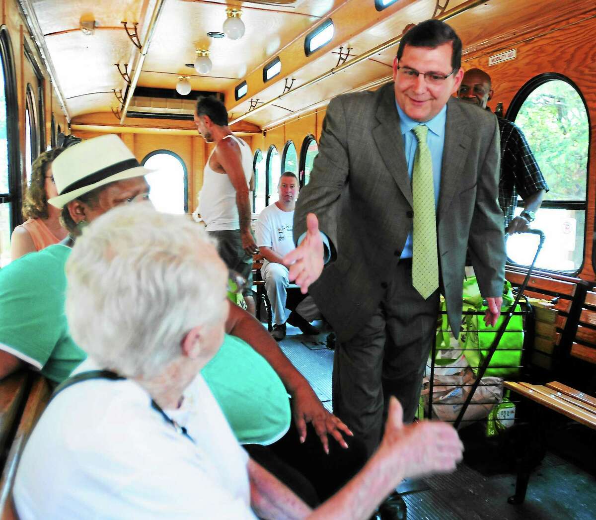 (Photo by Peter Hvizdak — Register)Edward O'Brien, who may have defeated four-term Mayor John M. Picard with a 12-vote lead in Tuesday's Democratic primary, shake hands with Lilly Rechbart, left, and Theresa Andrews, second from left, while on the Trolley in front of the Seaside apartment building on Oak Street in West Haven Wednesday, September 11, 2013