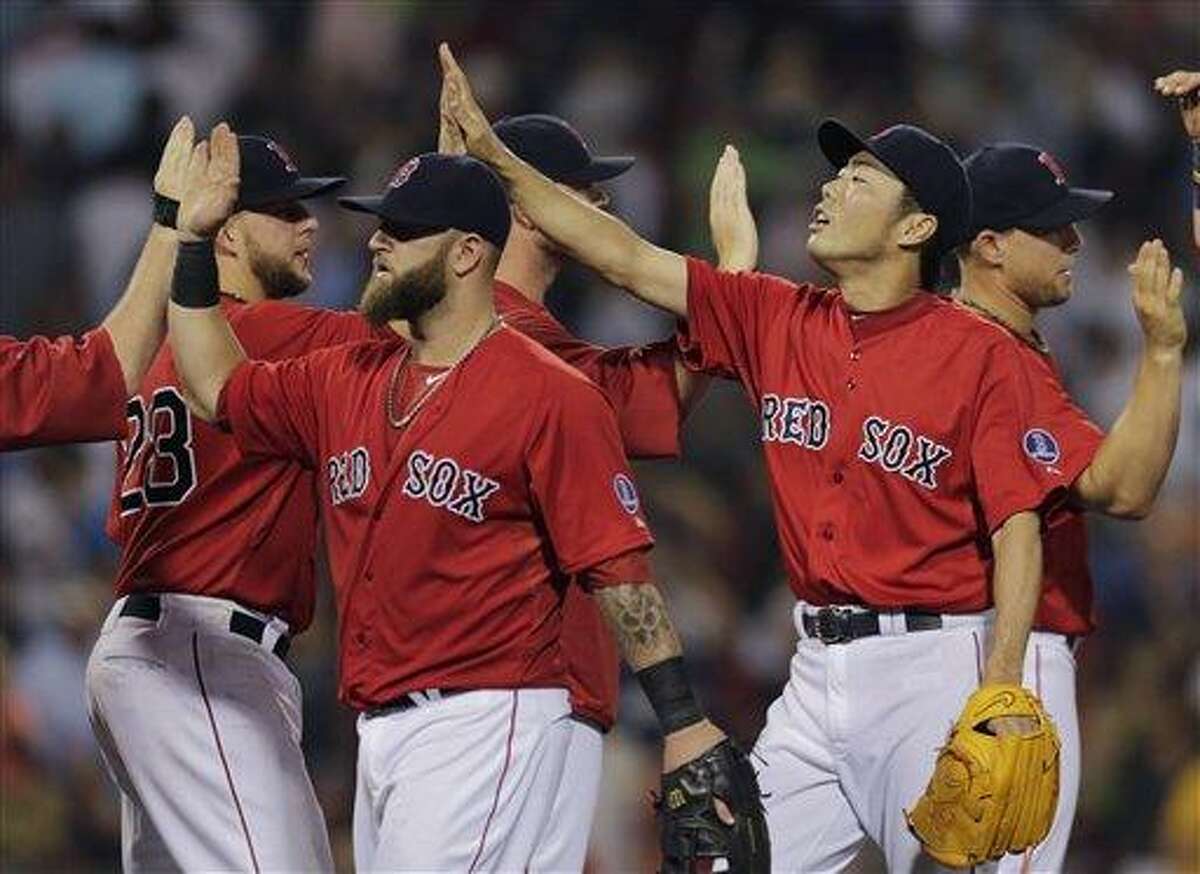 Boston Red Sox relief pitcher Koji Uehara is congratulated by teammates after beating the New York Yankees 4-2 during of a baseball game at Fenway Park, Friday, July 19, 2013, in Boston. (AP Photo/Charles Krupa)