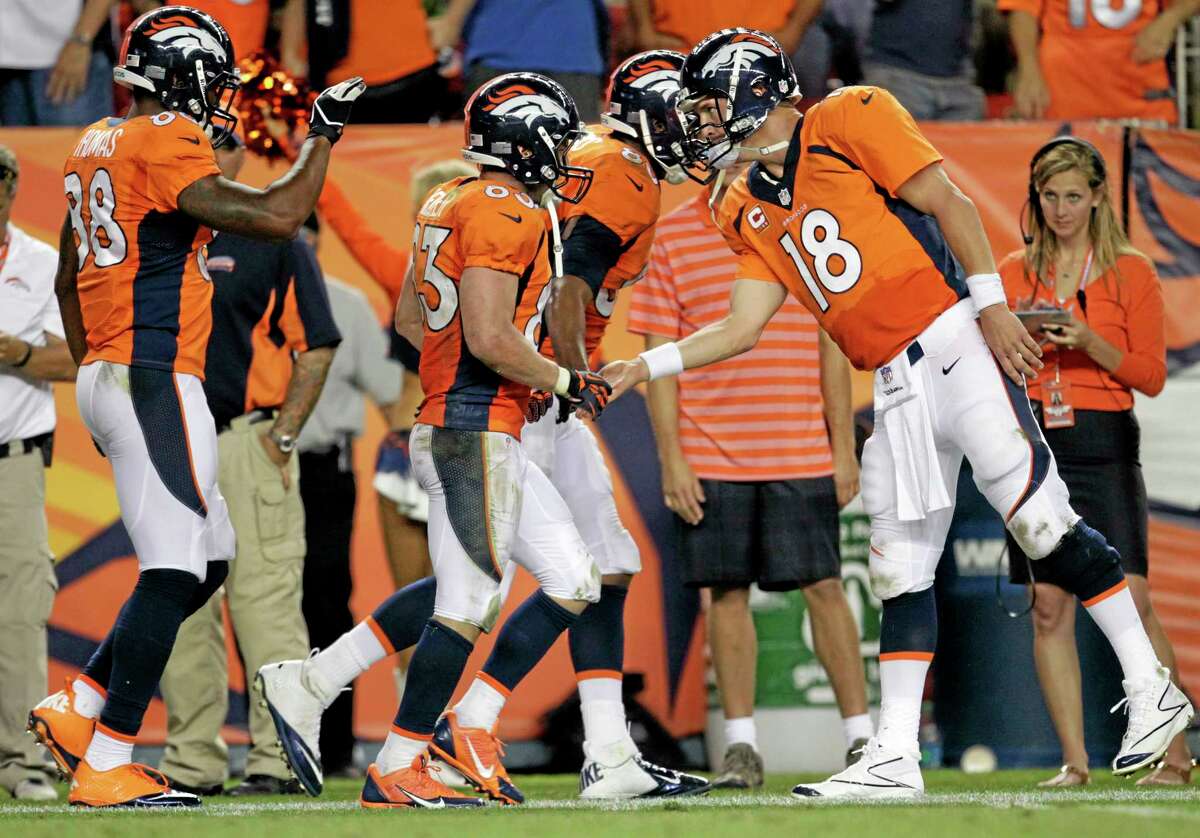 Broncos quarterback Peyton Manning (18) greets teammate Wes Welker (82) after a touchdown pass during the second half of their Sept. 5 game in Denver.