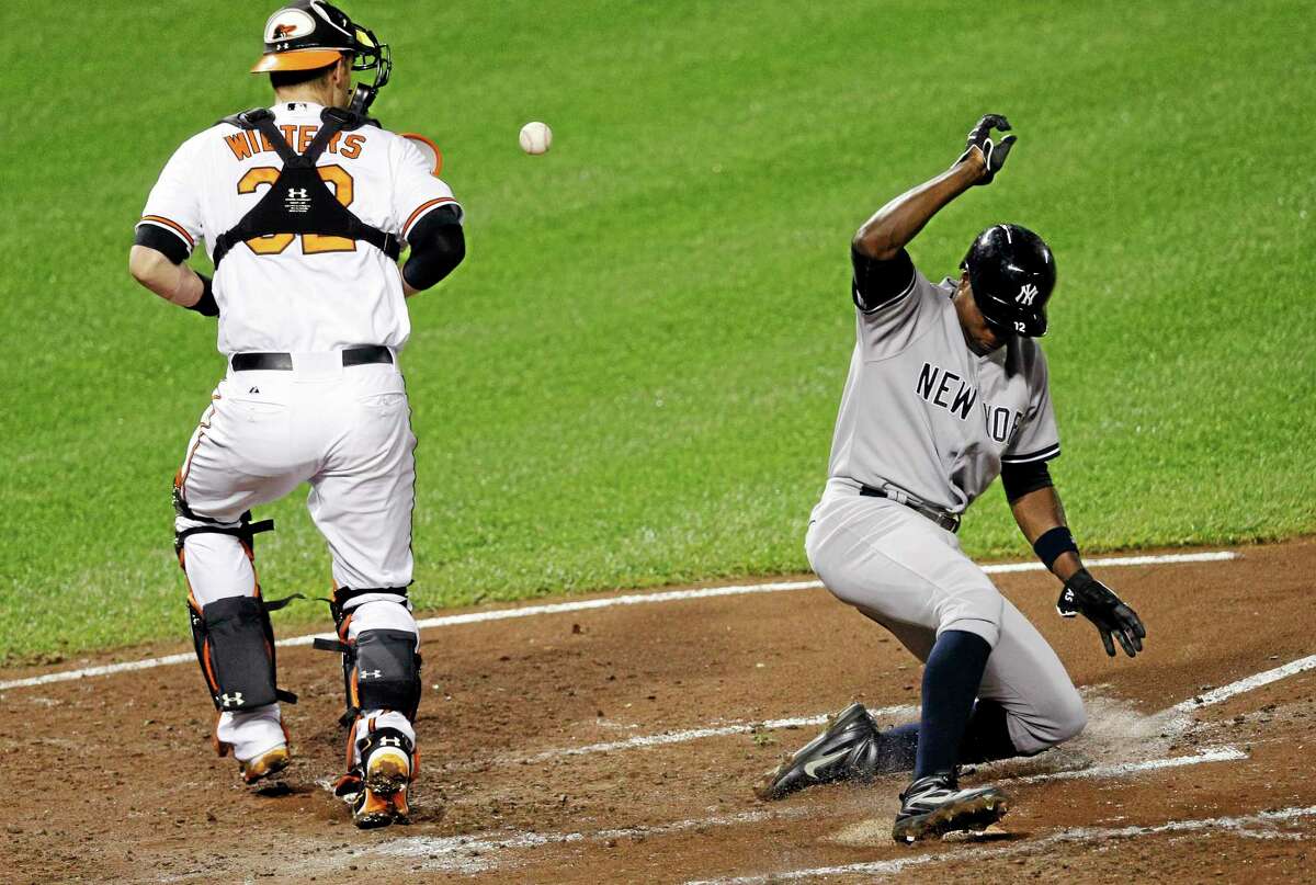 The Yankees’ Alfonso Soriano slides safely into home past Orioles catcher Matt Wieters Thursday in Baltimore. Soriano was scratched Saturday in Boston.