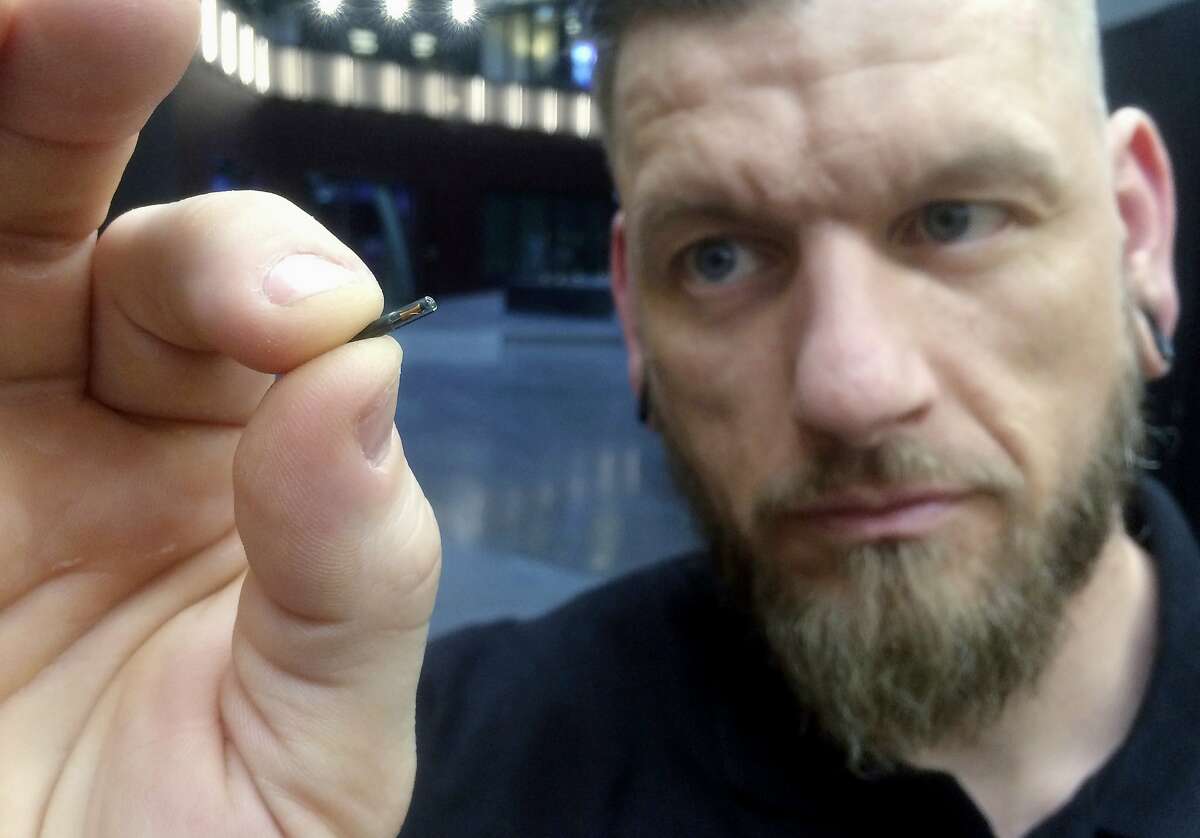 Jowan Osterlund from Biohax Sweden holds a small microchip implant, similar to those implanted into workers at Epicenter, a digital innovation business center in Stockholm. 