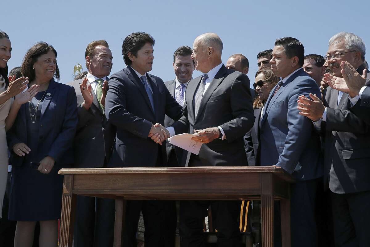 Senate President pro Tempore Kevin de Le�n and Gov. Jerry Brown shake hands following a signing ceremony at Treasure Island on Tuesday, July 25, 2017, in San Francisco, Calif. Gov. Jerry Brown signed AB 398, a bill extending California's cap-and-trade system. He signed it on the same spot where former California Gov. Arnold Schwarzenegger signed the state's landmark 2006 climate change law, AB 32, which led to the creation of the cap-and-trade system.