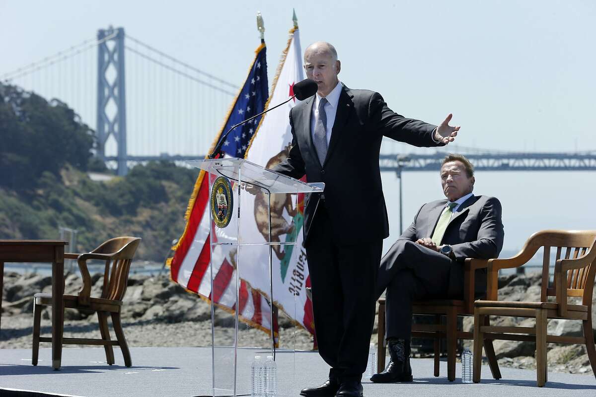Gov. Jerry Brown gives his remarks during a signing ceremony at Treasure Island on Tuesday, July 25, 2017, in San Francisco, Calif. Gov. Jerry Brown signed AB 398, a bill extending California's cap-and-trade system. He signed it on the same spot where former California Gov. Arnold Schwarzenegger (seen in the background) signed the state's landmark 2006 climate change law, AB 32, which led to the creation of the cap-and-trade system.