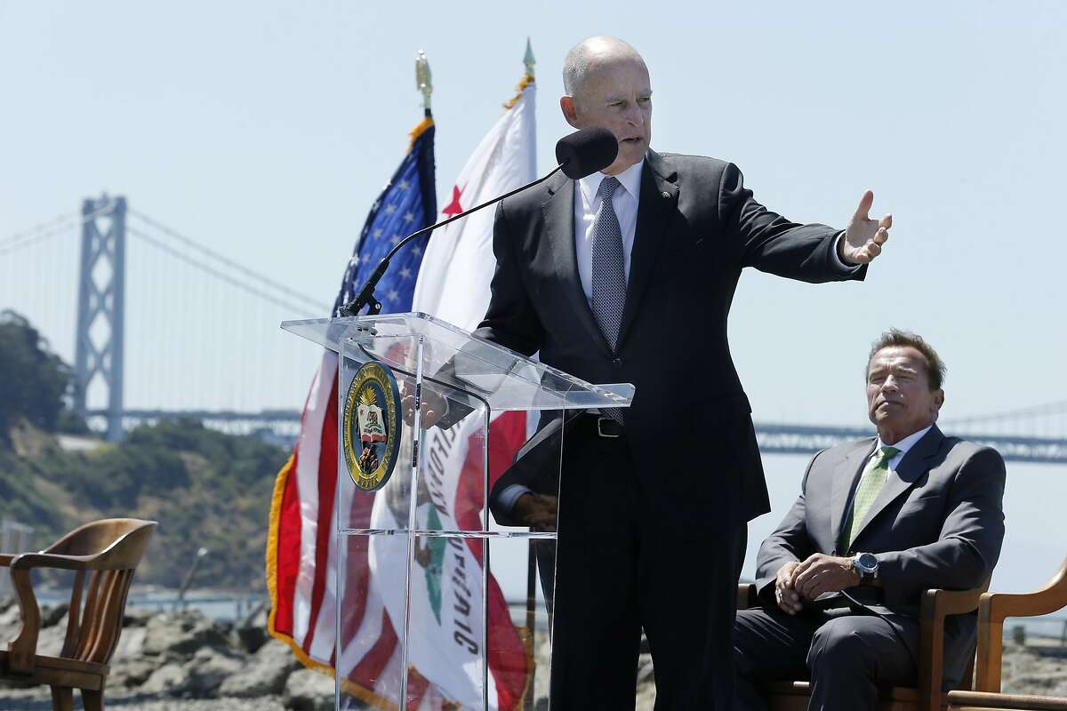 Gov. Jerry Brown gives his remarks during a signing ceremony at Treasure Island on Tuesday, July 25, 2017, in San Francisco, Calif. Gov. Jerry Brown signed AB 398, a bill extending California's cap-and-trade system. He signed it on the same spot where former California Gov. Arnold Schwarzenegger (seen in the background) signed the state's landmark 2006 climate change law, AB 32, which led to the creation of the cap-and-trade system.