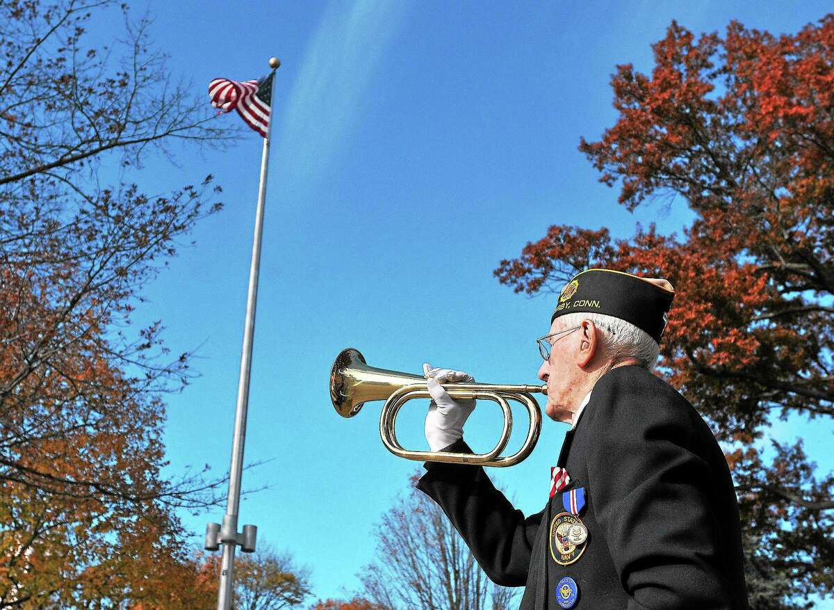 (Peter Casolino — New Haven Register) WWll Navy veteran, Daniel R. Waleski, 89, "plays" taps during the annual Veteran's Day observance ceremony on the Derby Green. pcasolino@NewHavenRegister