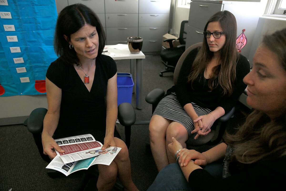 UCSF director for women centered contraception Dr. Christine Dehlendorf (left) talks with project managers Whitney Wilson (middle) and Reiley Reed (right) about teen pregnancy intervention materials on Friday, July 21, 2017, in San Francisco, Calif. The UCSF program will be loosing $2.8 million federal funding of the $213.6 million awarded by the Obama administration to find scientifically valid ways to help teenagers avoid pregnancy.