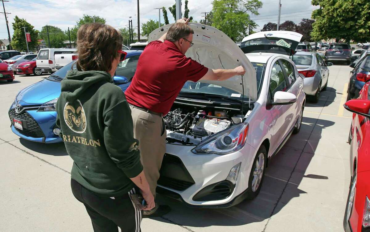 In this Tuesday, June 13, 2017, photo, Mark Miller Toyota salesman Doug Lund shows the engine of a Prius C Hybrid to shopper Mary Jean Jones, in Salt Lake City. The Conference Board releases its July index on U.S. consumer confidence, Tuesday, July 25, 2017. (AP Photo/Rick Bowmer)