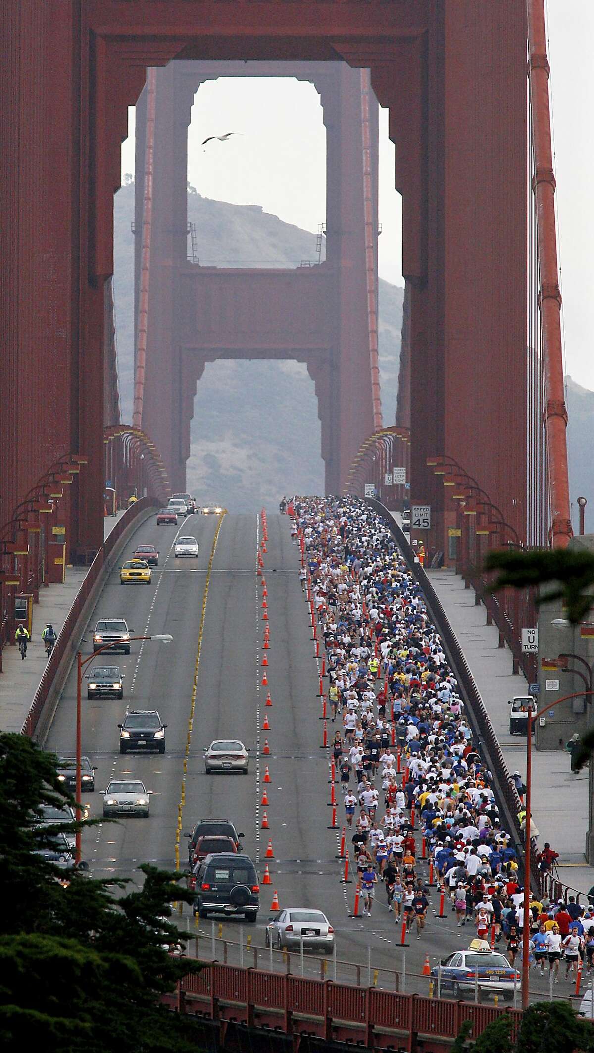 FILE - In this July 30, 2006 file photo, San Francisco marathon runners cross the Golden Gate Bridge. For the first time, northbound lanes of the Golden Gate Bridge will be closed during the San Francisco Marathon due to terrorism concerns. Bridge operators decided to keep motorists out of those lanes in this year's marathon between 6 to 9 a.m. Sunday, July 23, 2017, after several terrorist attacks occurred where drivers intentionally plowed into pedestrians. Southbound lanes will be kept open because runners are protected from southbound vehicles by a steel-and-concrete median barrier. (Brant Ward/San Francisco Chronicle via AP, File)