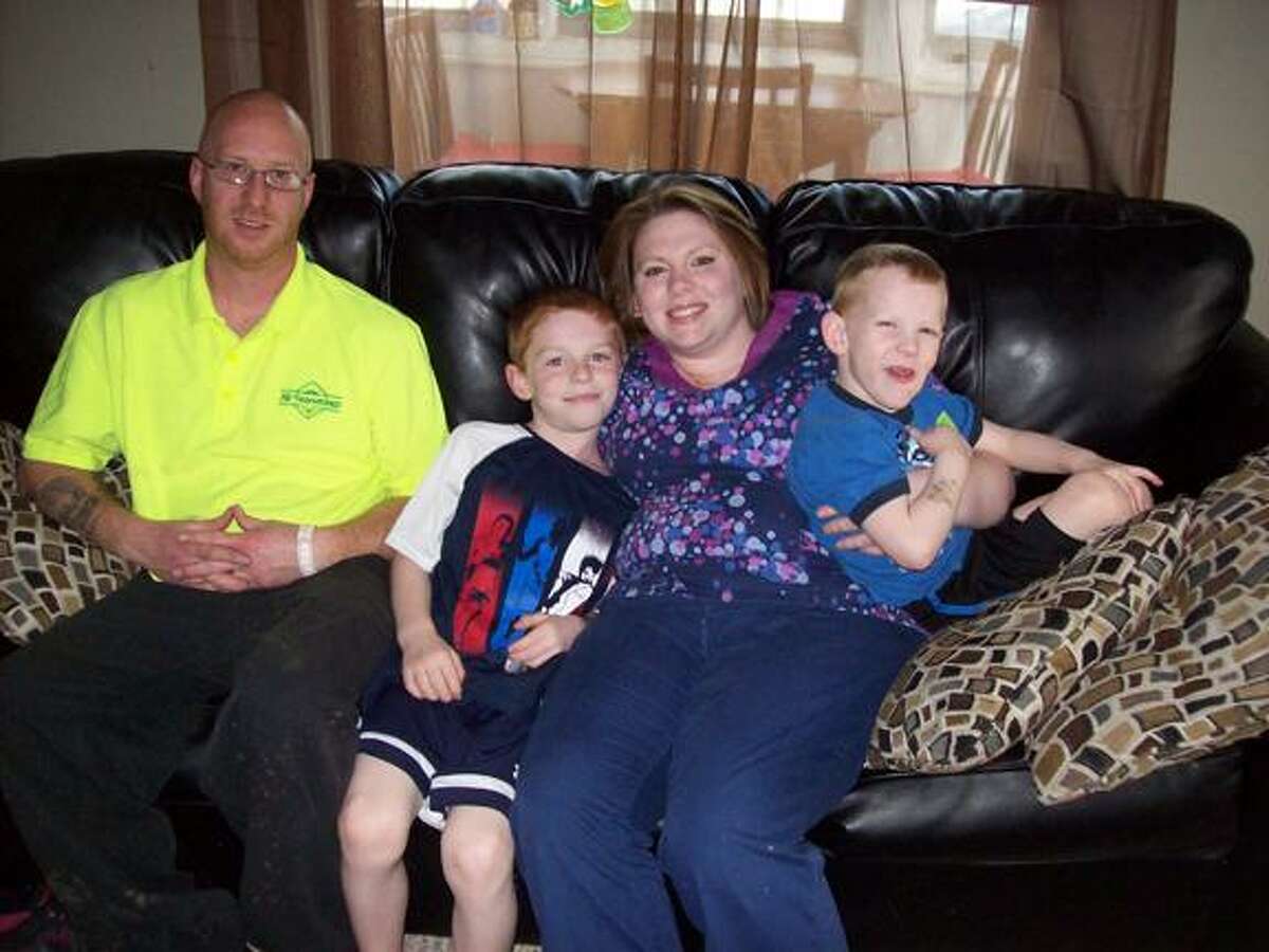 Mike Jaquays/ Special to the Dispatch Jessica Froelick poses with, from left, her husband Joe Froelick and their children Tyler, 7, and Logan, 4, in their Oneida home on May 17. At 29 years old, she is a stage 3 breast cancer survivor, and will share her inspiring story at the Relay for Life of Madison County on June 1 at the Oneida High School track.