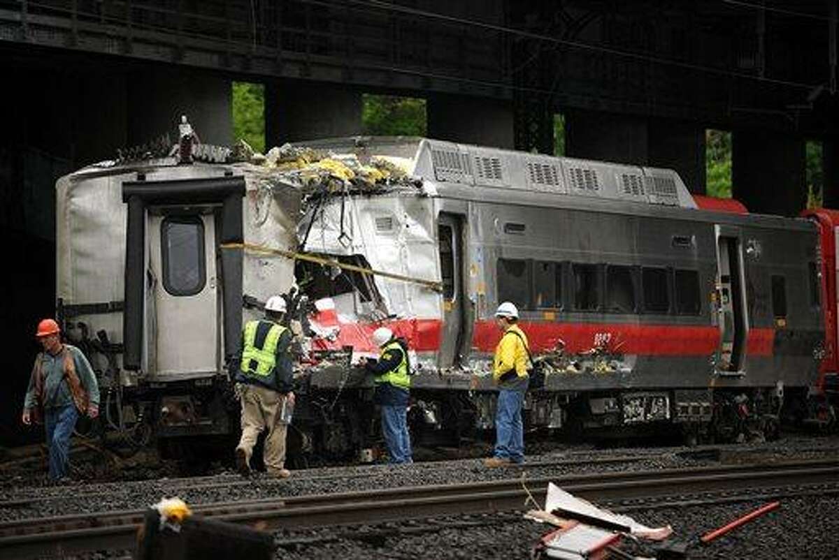 Metro-North employees work at the site of Friday's train derailment in Bridgeport. Conn. on Sunday, May 19, 2013. Crews will spend days rebuilding 2,000 feet of track, overhead wires and signals following the collision between two trains Friday evening that injured 72 people, Metro-North President Howard Permut said Sunday. (AP Photo/The Connecticut Post,Brian A. Pounds ) MANDATORY CREDIT