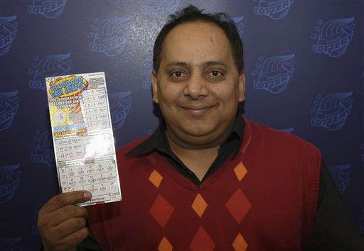 FILE - This undated file photo provided by the Illinois Lottery shows Urooj Khan, 46, of Chicago's West Rogers Park neighborhood, posing with a winning instant lottery ticket. On Friday, Jan 11, 2013, a Cook County judge granted authorities permission to exhume the body of the Chicago lottery winner who was fatally poisoned with cyanide just as he was about to collect his $425,000 payout. His July 20 death was initially ruled a result of natural causes. (AP Photo/Illinois Lottery, File)