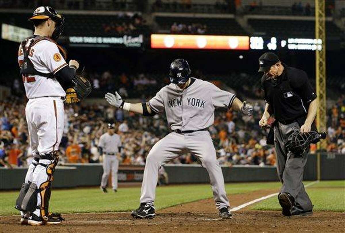 New York Yankees designated hitter Travis Hafner, center, crosses home plate after hitting a solo home run in the ninth inning of a baseball game against the Baltimore Orioles in Baltimore, Monday, May 20, 2013. New York won 6-4 in 10 innings. (AP Photo/Patrick Semansky)