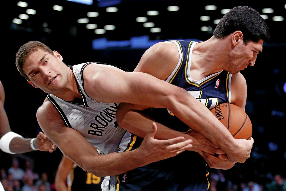 The Nets’ Brook Lopez, left, fights for possession with the Jazz’s Enes Kanter during Tuesday’s game in Brooklyn.