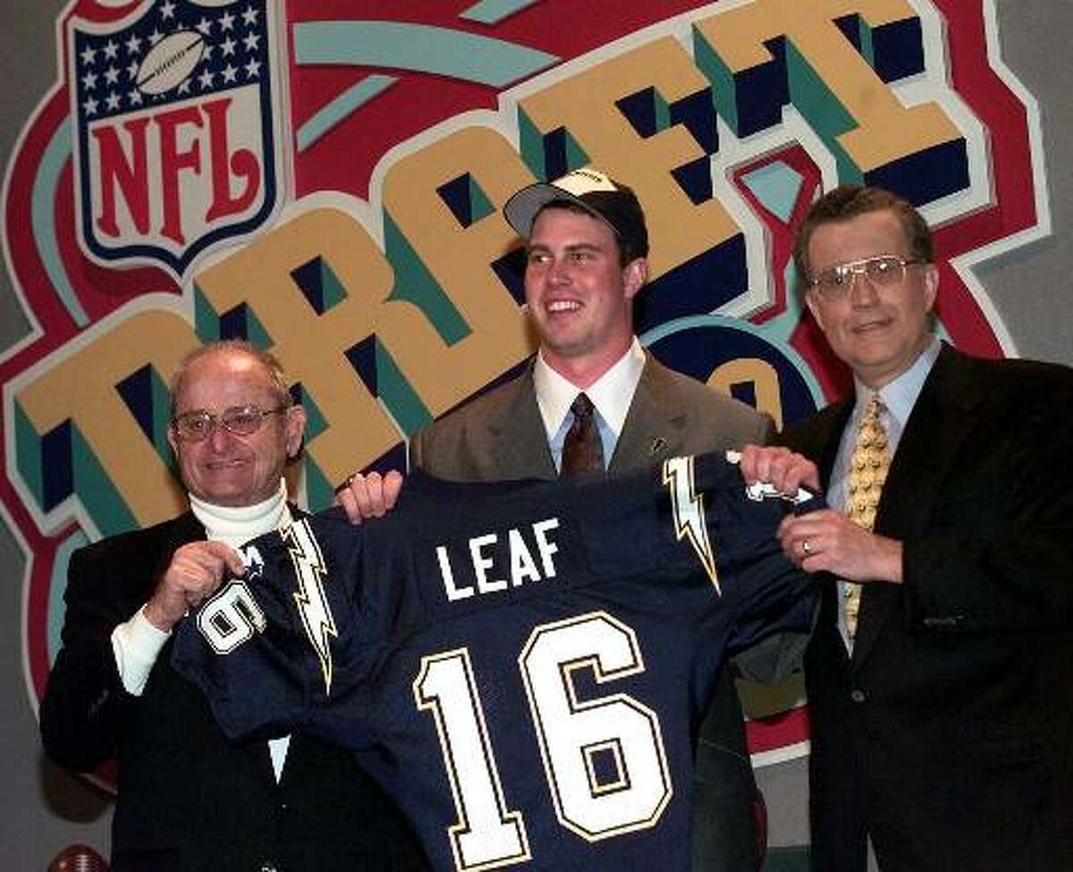 Ryan Leaf, center, of Washington State gets help holding up his San Diego Chargers jersey by Chargers owner Alex Spanos, left, and NFL commissioner Paul Tagliabue after Leaf was chosen by the Chargers as the second pick overall in the NFL draft Saturday, April 18, 1998 in New York. (AP Photo/Mark Lennihan)