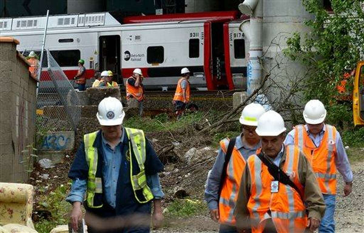 Metro-North Railroad officials tour the scene of the train derailment, Saturday, May 18, 2013 in Bridgeport, Conn. Officials described a devastating scene of shattered cars and other damage where two trains packed with rush-hour commuters collided in Connecticut, saying Saturday it's fortunate that no one was killed and that there weren't even more injuries. (AP Photo/Connecticut Post, Christian Abraham) MANDATORY CREDIT
