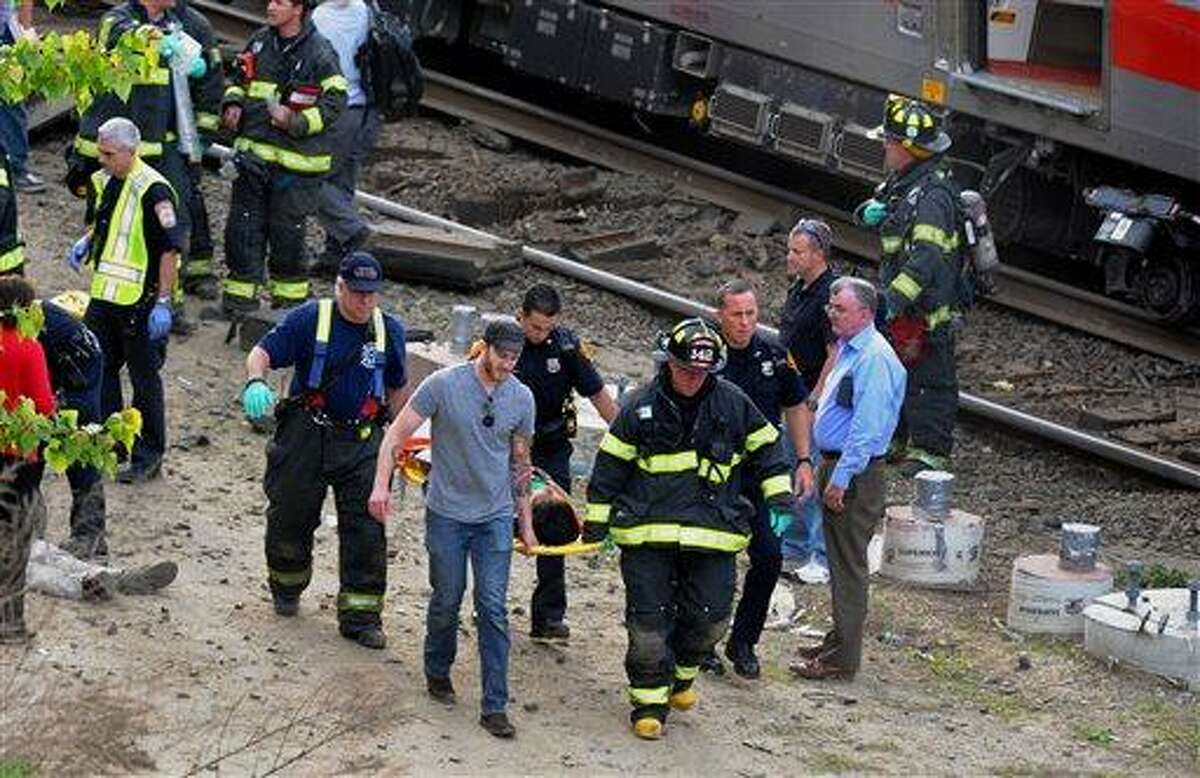 Injured passengers are transported from the scene where two Metro North commuter trains collided, Friday, May 17, 2013 near Fairfield, Conn. Bill Kaempffer, a spokesman for Bridgeport public safety, told The Associated Press approximately 49 people were injured, including four with serious injuries. About 250 people were on board the two trains, he said. (AP Photo/The Connecticut Post, Christian Abraham)