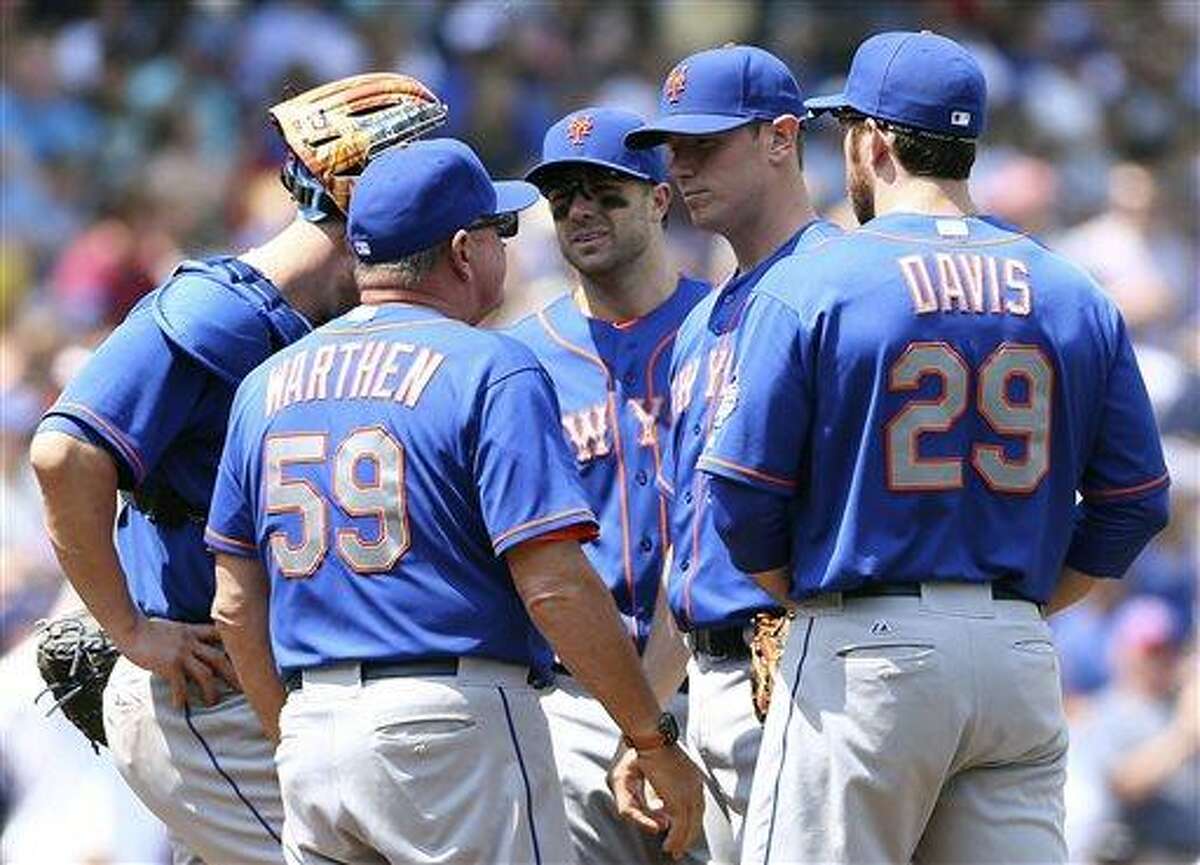 New York Mets pitching coach Dan Warthen has a meeting on the mound after starting pitcher Jeremy Hefner, second from right, gave up four runs in the fourth inning of a baseball game against the Chicago Cubs Saturday, May 18, 2013, in Chicago. Other players on the mound are, from left, John Buck, David Wright and Ike Davi . (AP Photo/Charles Cherney)