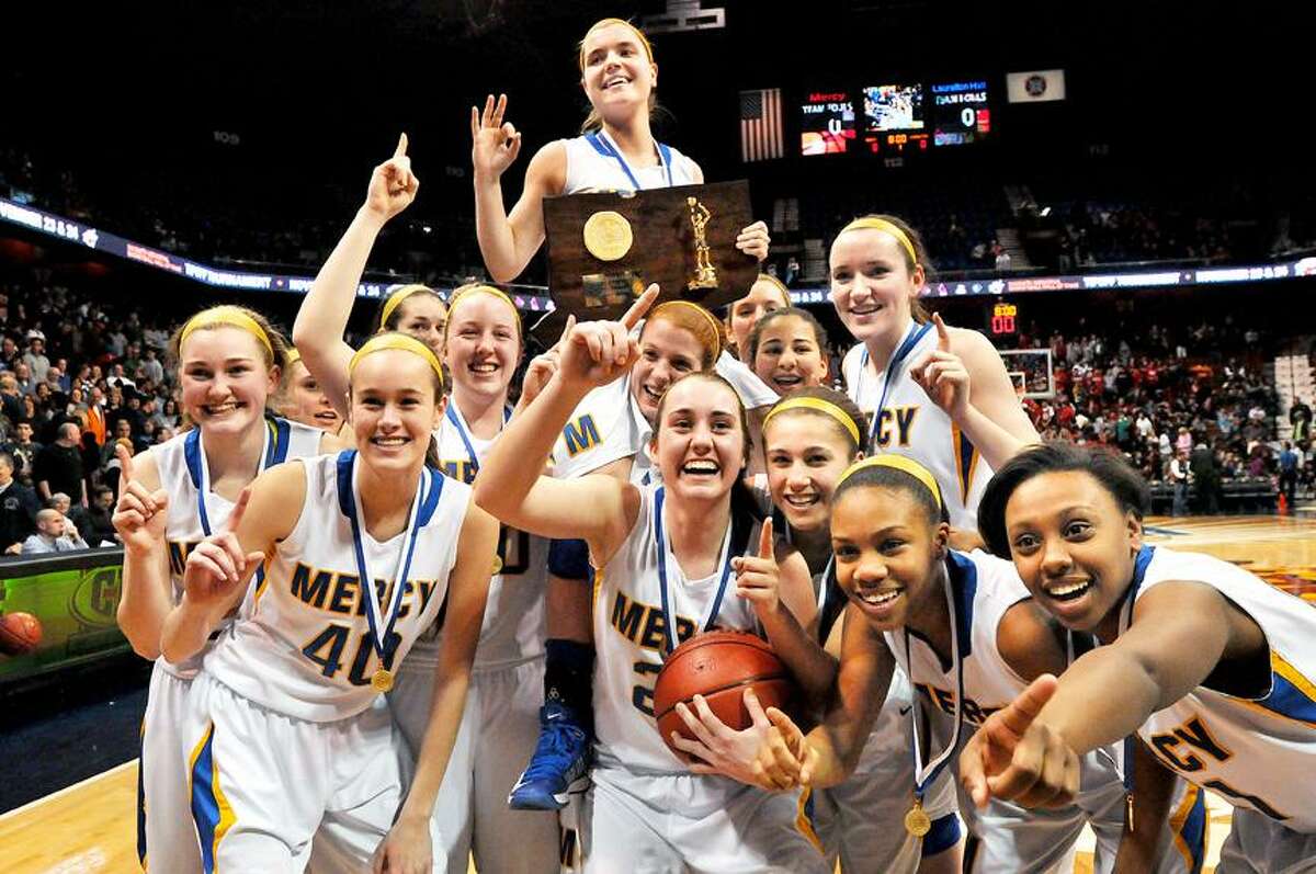 Catherine Avalone/The Middletown Press Mercy senior captain Maria Weselyj is lifted by her onto the shoulders of Liz Falcigno by her teammates after hitting a 3 point buzzer shot to defeat Lauralton Hall-Milford 54-53 in the Class LL State Championship game at Mohegan Sun Saturday evening.