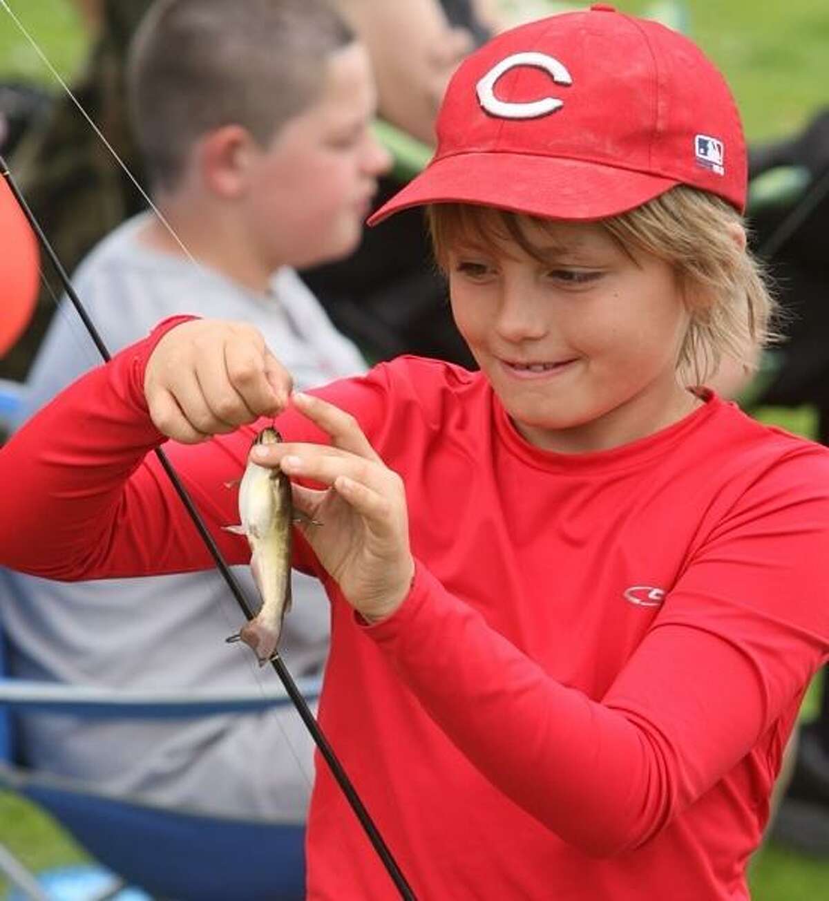 PHOTO BY JOHN HAEGER @ ONEIDAPHOTO ON TWITTER/ONEIDA DAILY DISPATCH Shane Plack ,10, of Canastota works to take a fish off the hook during the annual fishing derby in Sherrill on Saturday, May 18, 2013.