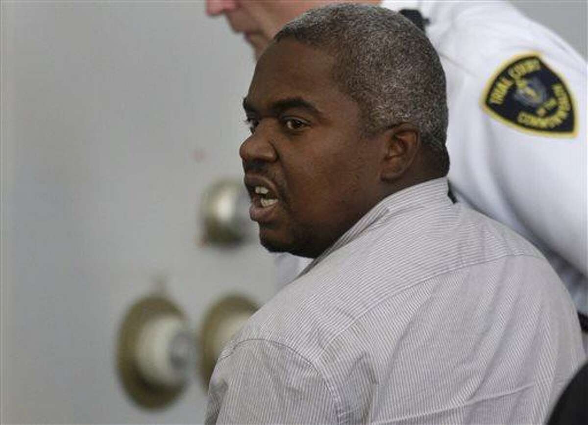 Ernest Wallace, of Miramar, Fla., mouths words to people sitting in Attleboro District Court, in Attleboro, Mass., as he is escorted from the court room after pleading not guilty during his arraignment, Monday, July 8, 2013. Wallace is facing an accessory to murder charge in the case involving former New England Patriots tight end Aaron Hernandez and has been ordered held without bail. (AP Photo/Steven Senne, Pool)