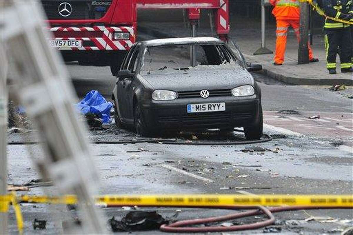 A damaged car remains in the street after a helicopter crashed into a construction crane on top of St George's Wharf tower building, in London, Wednesday. Police say two people were killed when a helicopter crashed during rush hour in central London after apparently hitting a construction crane on top of a building. AP Photo/Vince Pol