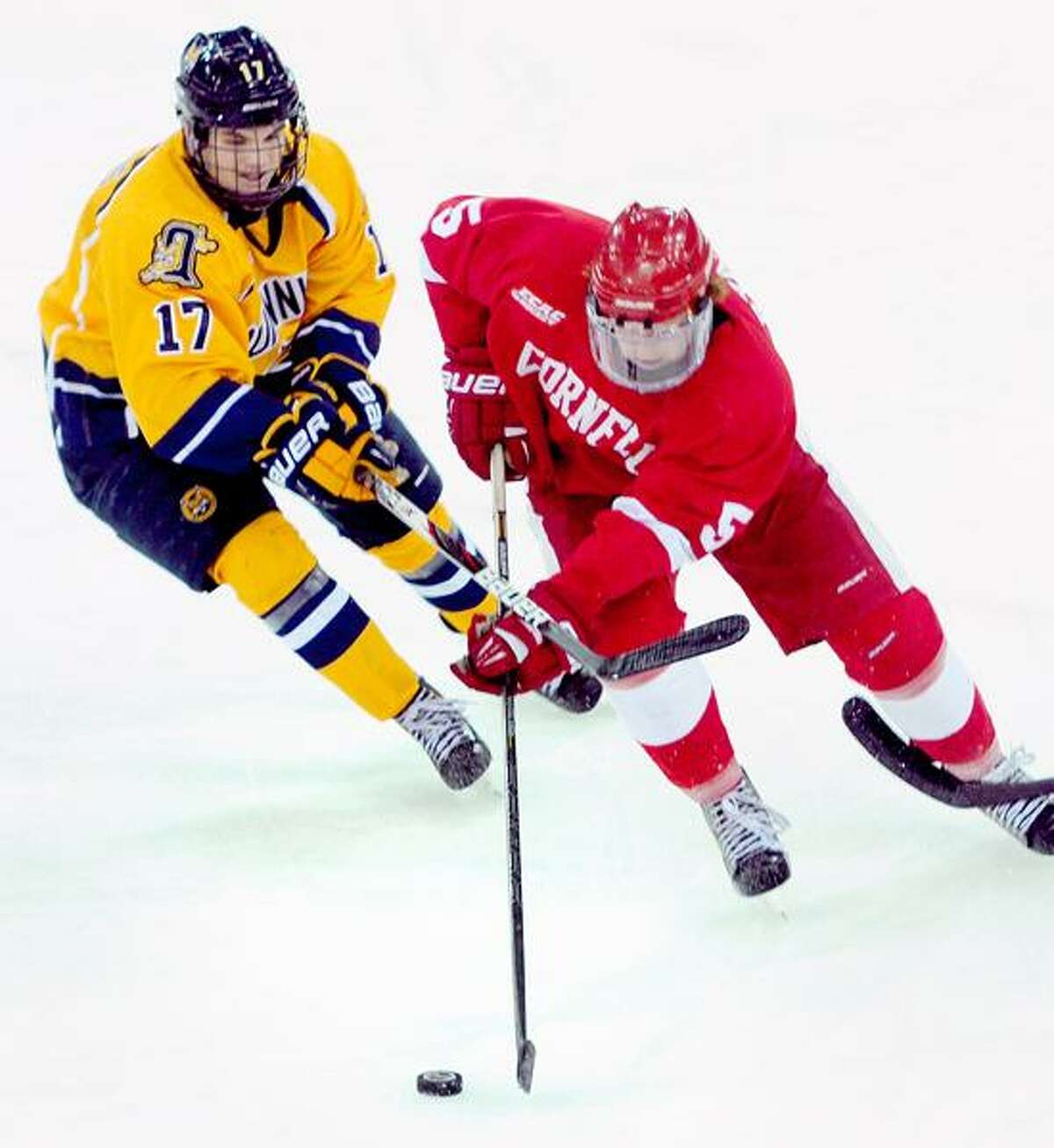 Jeremy Langlois (left) of Quinnipiac and Joakim Ryan (right) of Cornell fight for the puck in the second period during a ECAC quarterfinal contest on Friday. Arnold Gold/New Haven Register