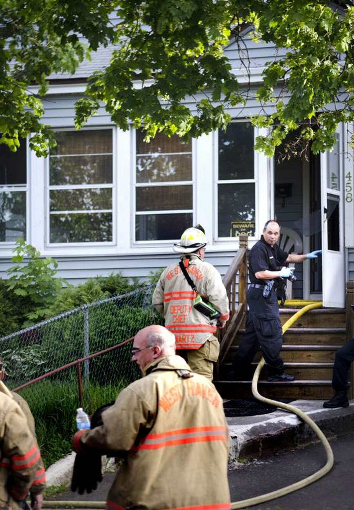 West Haven- A police photographer enters the home, on First Street, where a fatal fired occured. Melanie Stengel/Register
