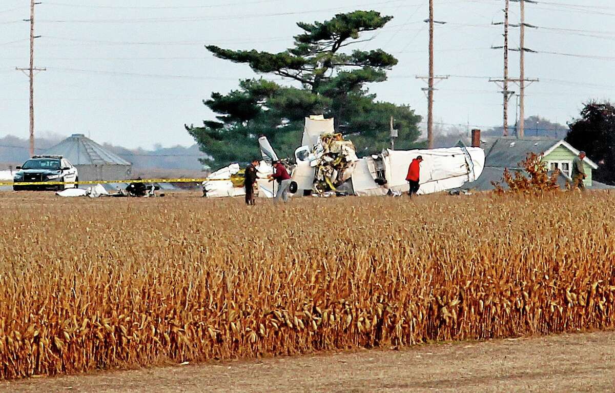 Emergency personnel work at the scene of a plane crash in a farm field near Houston County Airport in southeastern Minnesota on Friday, Nov. 1, 2013. Three people were killed in the crash that was and one person in critical condition according to authorities. (AP Photo/The La Crosse Tribune, Peter Thomson)