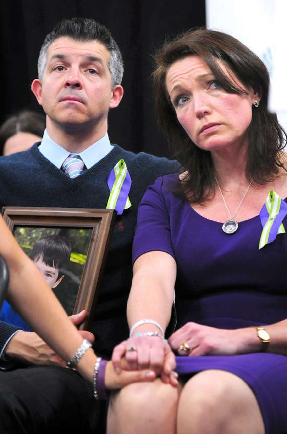 Ian Hockley (left) holding a photograph of his son, Dylan, and his wife, Nicole (right), listen to speakers a press conference announcing the launch of Sandy Hook Promise at Edmond Town Hall in Newtown on 1/14/2013. Dylan was killed in the Sandy Hook Elementary School shootings.Photo by Arnold Gold/New Haven Register