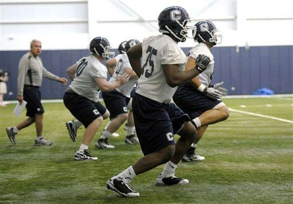 Connecticut offensive coordinator George DeLeone, rear left, runs drills during the first day of the team's spring NCAA college football practice, Tuesday, March 20, 2012, in Storrs, Conn. (AP Photo/Sean D. Elliot, The Day)