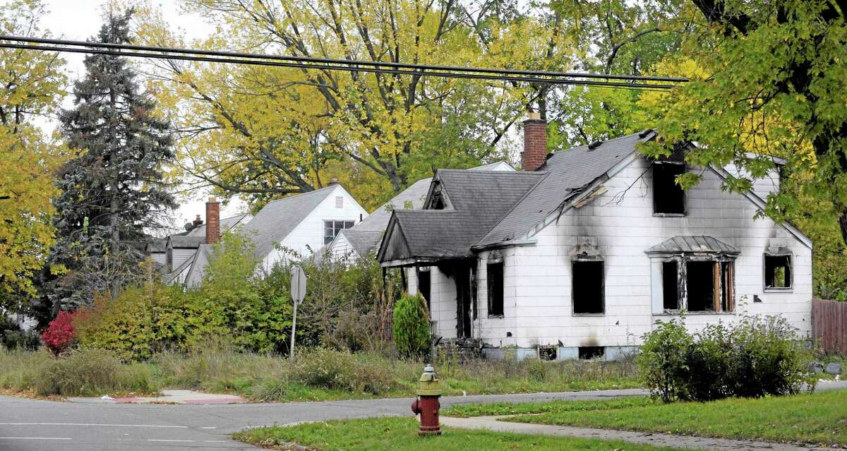 Burned out and vacant homes in Detroit. Mich. Saturday Oct. 26, 2013. Detroit Public Schools and The Detroit Fire Department teamed up to board up old homes and clear out blighted structures and overgrowth in the Burt and Tireman neighborhood. (AP Photo/The Detroit News, Todd McInturf)