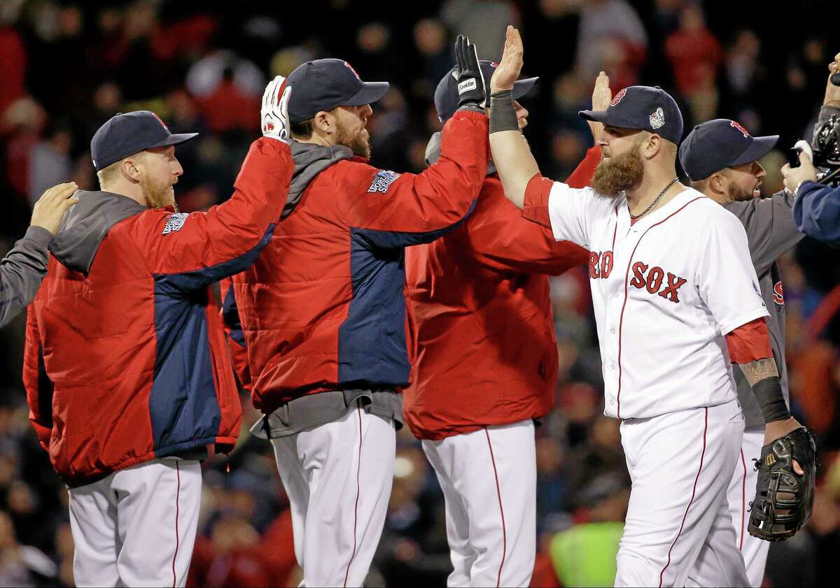 Boston Red Sox’s Mike Napoli, right, celebrates with John Lackey, center, and teammates after Game 1 of the World Series against the St. Louis Cardinals.
