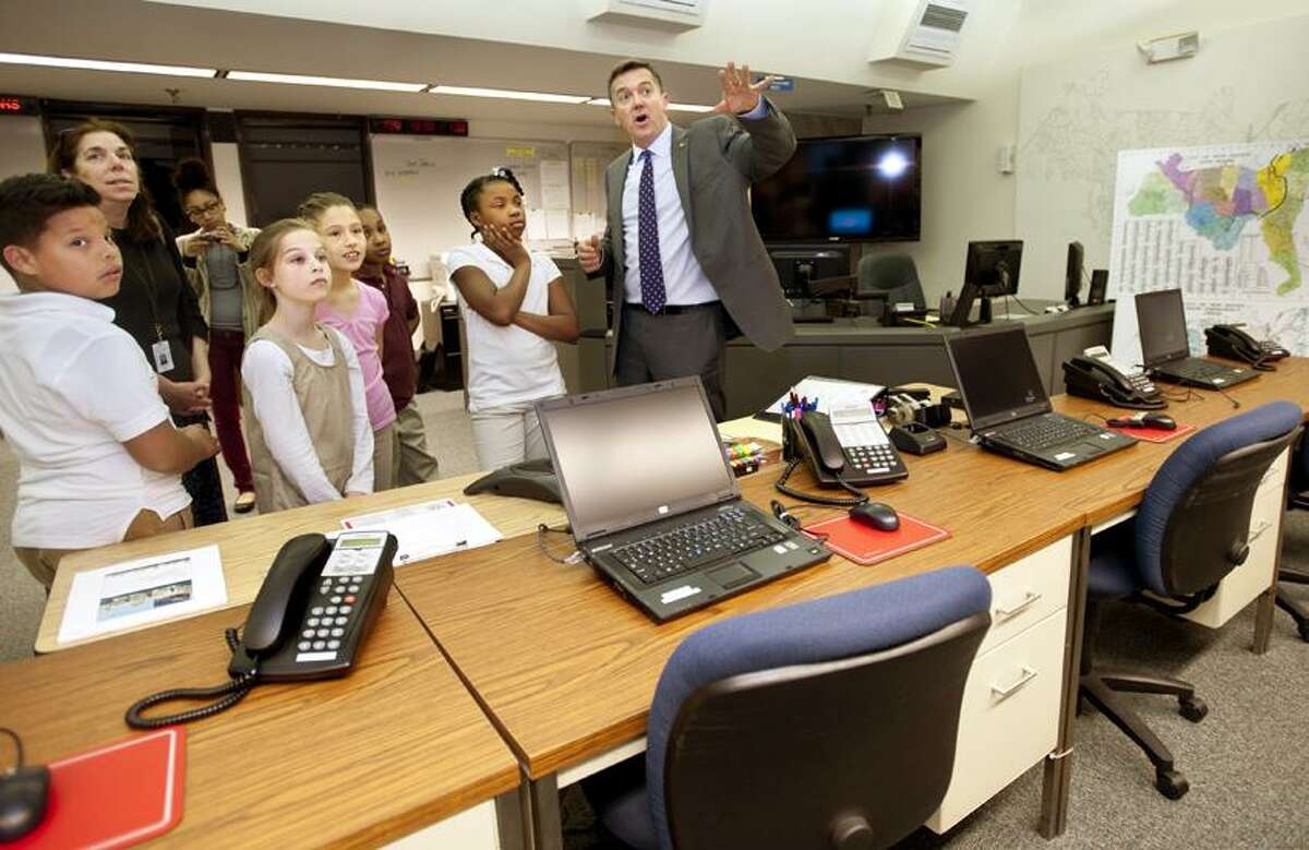 NEWHAVEN-Jim Travers, Director of Transportation, Parking and Traffic, shows a group of 5th graders from Jackie Robinson around the emergency command center at 200 Orange Street.