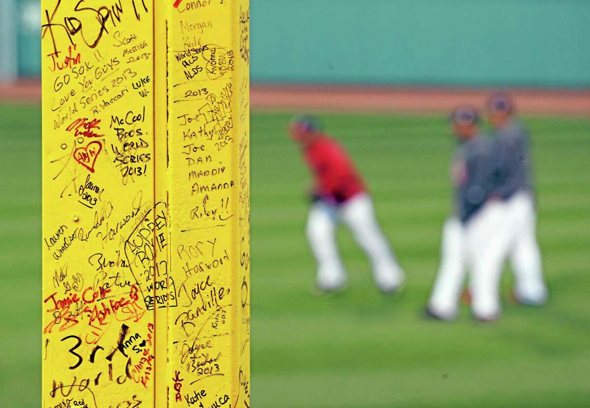 Fans’ signatures are seen on “Pesky’s Pole” in right field at Fenway Park as the Boston Red Sox practice before Game 2 of the World Series on Thursday.