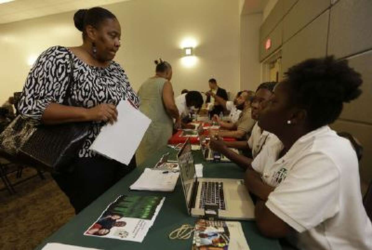 In this Oct. 3, 2013 photo, Velicia Martin, 53, of Miami, left, talks with employees with the Jesse Trice Community Center about insurance options under the Affordable Care Act. Due to technology problems with a federal government website, many were unable to enroll online for the first few days of the program.