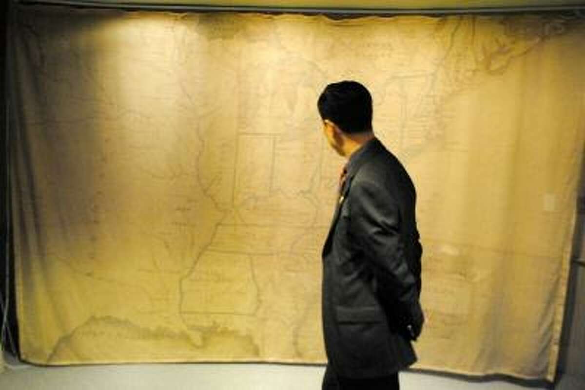 A Chinese judge studies a colonial map of the United States. JESSICA GLENZA/REGISTER CITIZEN.