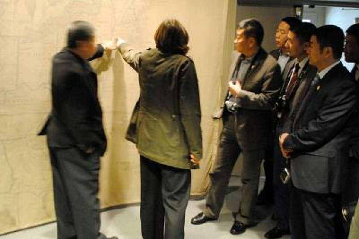 Chinese judges learn about the American judiciary system and American history. Pictured above, Cathy Fields, Director of the Litchfield Historical Society, points out Litchfield on a colonial map of America. JESSICA GLENZA/REGISTER CITIZEN.