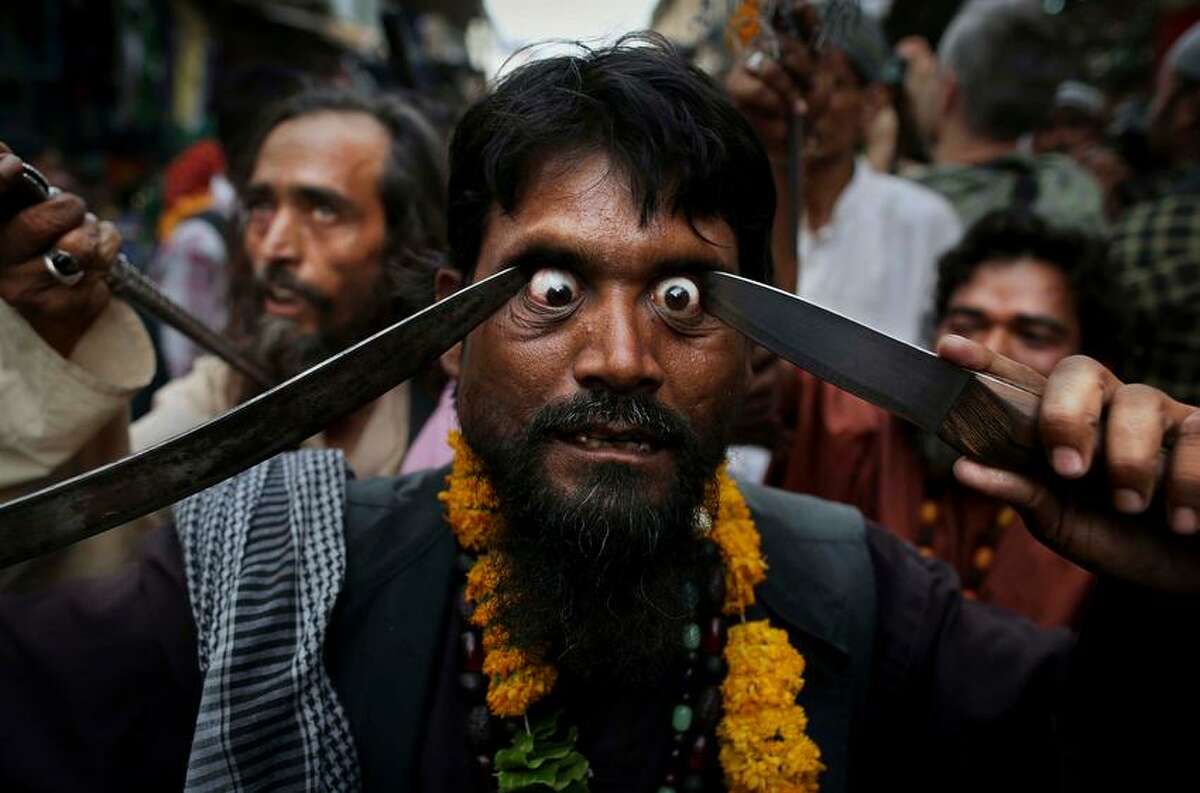 In this Saturday, May 11, 2013 photo, an Indian Muslim Sufi holy man self-flagellates himself with sharp objects during a procession at the shrine of Khwaja Moinuddin Chishti during the Urs festival in Ajmer, India. Thousands of Sufi devotees from different parts of India travel to the shrine for the annual festival, marking the death anniversary of Sufi Muslim saint Khwaja Moinuddin Chishti. (AP Photo/Kevin Frayer)