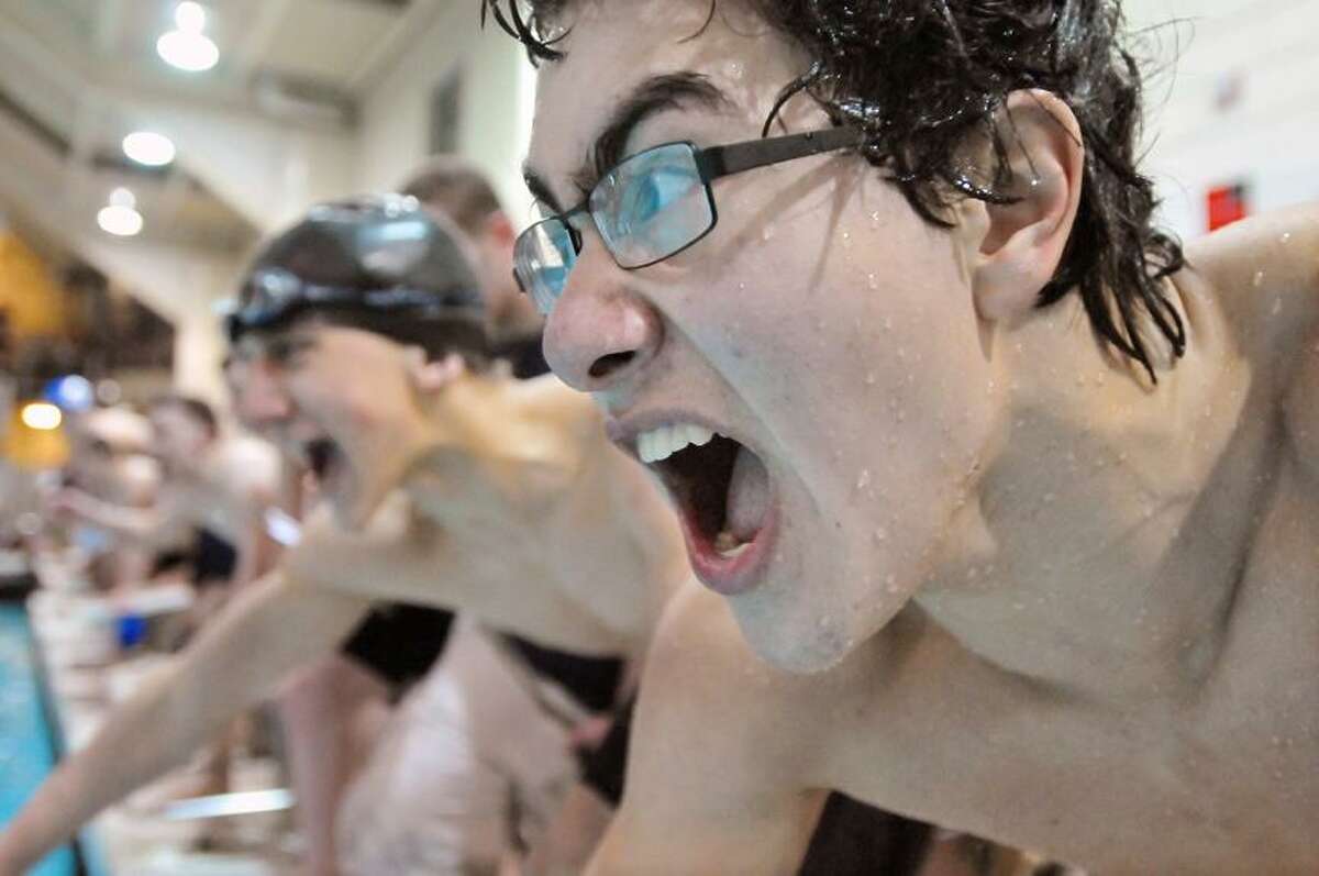Catherine Avalone/The Middletown Press Haddam-Killingworth senior captain Neal Tyson and junior Mike Szafran cheer on their teammate Garrett Mazziotti who finishes up the final leg in the 200 freestyle relay in the CIAC Class S Swim Championship at Wesleyan's Freeman Athletic Center. Tyson, Conor Champagne, Szafran and Mazziotti placed first with a time of 1:32.25.