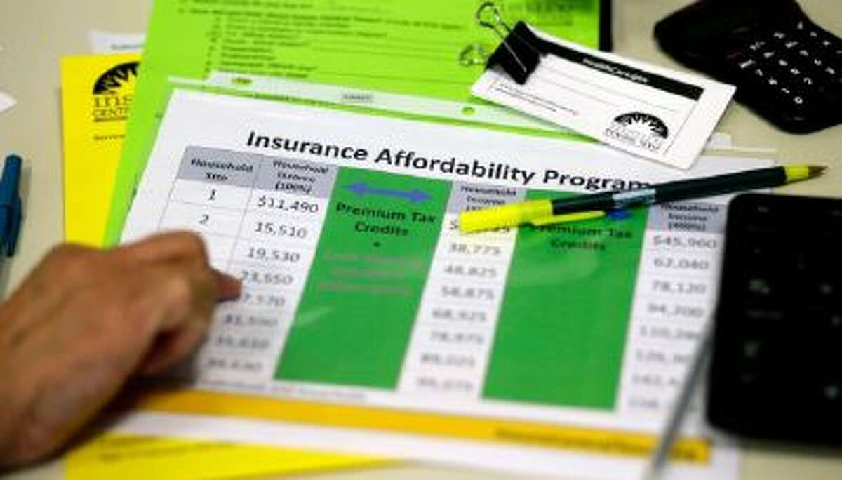 In this Oct. 1, 2013 photo, a volunteer counselor with Insure Central Texas uses a chart to help explain health insurance options in Austin, Texas.