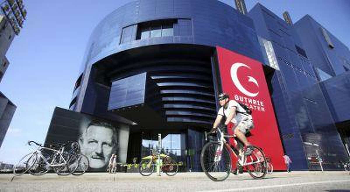 A biker pedals past the Guthrie Theater in the heart of the old milling district in Minneapolis, Minnesota July 2, 2013. REUTERS/Eric Miller (UNITED STATES - Tags: CITYSPACE TRAVEL)