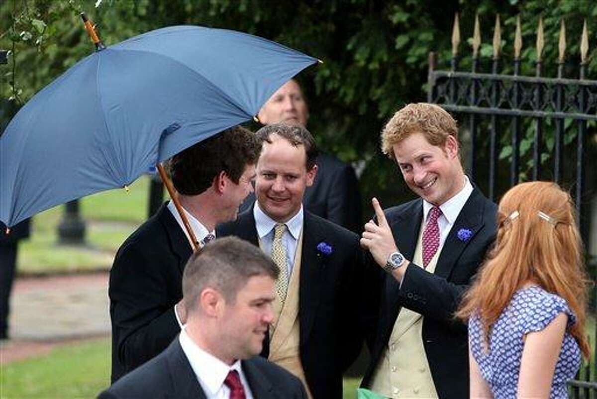 Britain's Prince Harry, right, leaves after attending the wedding of the Duke and Duchess of Northumberland's daughter Lady Melissa Percy to chartered surveyor Thomas van Straubenzee at St Michael's Church in Alnwick, England, Saturday, June 22, 2013. (AP Photo/Scott Heppell)